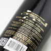 Detail fľaše bulharského vína Domaine Bessa Valley Petite Syrah s tmavorubínovou farbou vína.